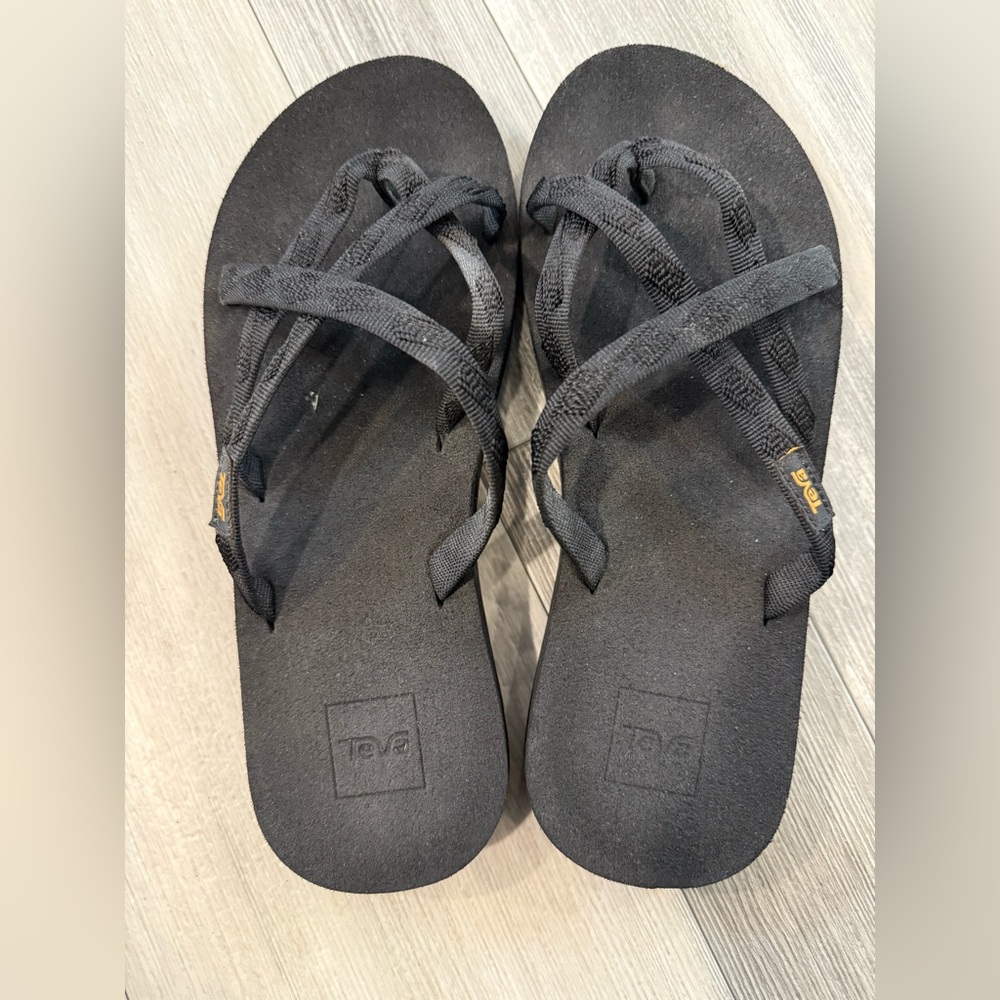 Teva Black Flip-Flops with Crisscross Straps.